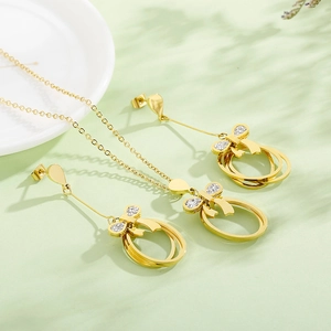 Detail view of gold stainless steel necklace and earrings set with crystal bows