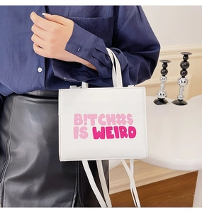 Detail of white square crossbody bag featuring purple artistic bold typography print