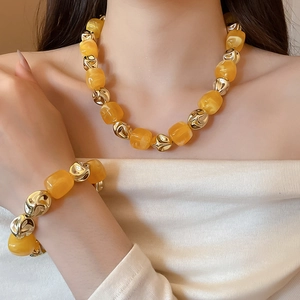 Macro view of irregular amber resin beads and gold metal links on a stylish bracelet
