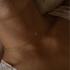 Elegant gold double-layered choker necklace featuring a delicate mini bow pendant for women