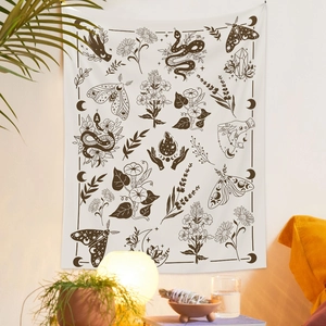 Détail d'une tapisserie bohème avec motifs papillon et serpent dans un décor cosy
