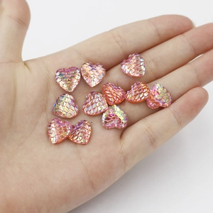 Macro shot of 12mm heart shaped resin flatback cabochons with iridescent fish scale texture