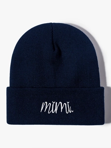 Detail view of navy blue knitted beanie with white mimi script embroidery on the cuff