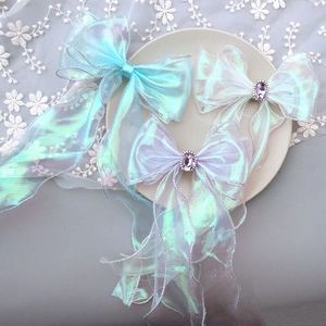 Close-up of iridescent blue bow hair clips with crystals and long ribbons for girls