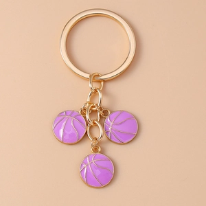 Detail of three purple enamel basketball charms with gold finish on a metal keychain