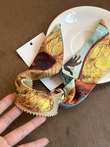 Detailed shot of sunflower print fabric hair accessory with golden bead trim edges