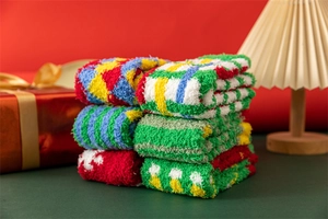 Close-up of thick coral fleece Christmas socks stacked neatly in warm festive lighting