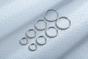 Multiple sizes of minimalist silver hoop earrings made of polished stainless steel