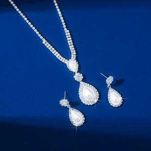 Elegant silver-toned necklace and teardrop pearl earrings set with sparkling rhinestones