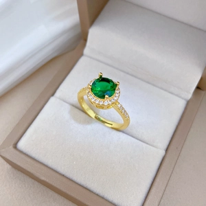 Adjustable gold ring featuring a green oval gemstone and micro-pave cubic zirconia