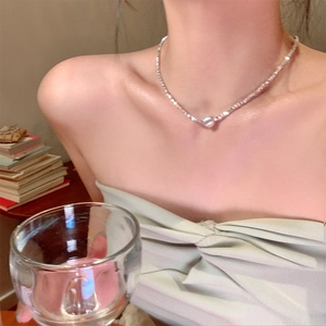 Elegant pearl necklace on a female model in a warm, sophisticated lifestyle setting