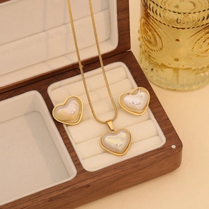 Vue macro de l'ensemble collier et boucles d'oreilles cœur avec nacre et cadre doré