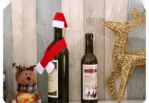 Détail d'un ensemble de bouteille de Noël avec mini bonnet rouge et écharpe sur bouteille