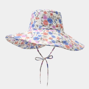 Détail d'un chapeau de soleil à large bord avec motif floral et jugulaire