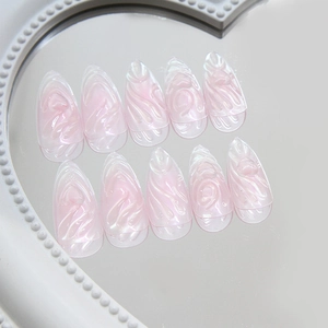 Motifs de cœur 3D sur ongles stiletto rose aurore à presser posés sur miroir