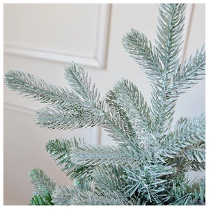 Macro shot of snowy pine needles with glitter finish for Christmas tree decoration