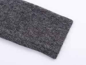Macro shot of dark grey knit fabric texture showing fine soft fiber details of the skirt