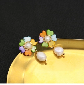 Detail of flower earrings with heart-shaped shell petals and natural drop pearls
