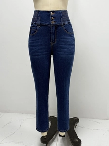 Detail of high waisted skinny jeans with triple button closure and elastic waistband