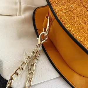 Detail of glitter pumpkin bag showing gold chain strap and high-quality lobster clasp buckle