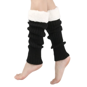 Detail view of black knitted leg warmers featuring plush white faux fur trim and cozy texture
