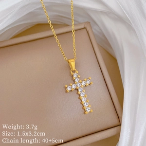 Gold stainless steel cross necklace with rhinestones on beige jewelry box with fabric