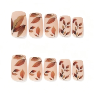 Press-on nails featuring autumn leaf patterns on a matte nude base in a square shape