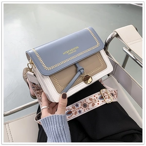 Detail of crossbody bag featuring wheat gold embroidery and ethnic floral strap