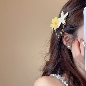 Detail of yellow chiffon daisy and starfish hair clip with colorful beaded gold chains