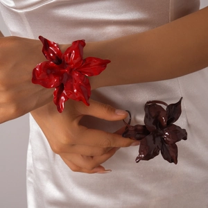 Detail of oversized floral bracelets with high-gloss finish in red and chocolate brown