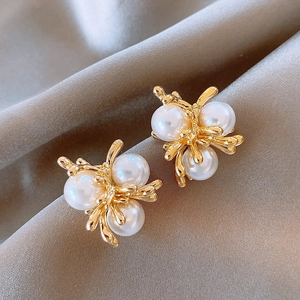 Elegant gold flower pearl stud earrings with a cluster design on gray silk background