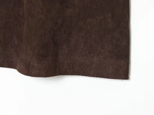 Vue macro du tissu en daim marron foncé avec des surpiqûres détaillées sur le gilet