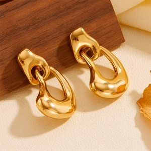 Detailed close-up of gold irregular interlocking hoop earrings on premium leather texture