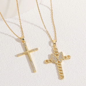 Close-up of zircon cross pendant and bow detail with 14K gold plated finish
