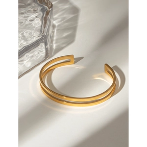 Artistic detail of 18k gold-plated double-line hollow bangle on white background
