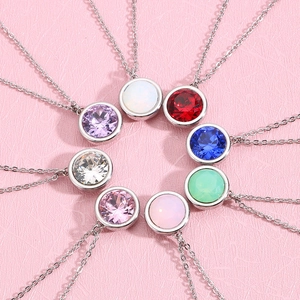 Close-up of eight colorful zircon pendants in a circular arrangement on pink background