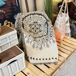 Detail of bohemian mandala throw blanket with fringed edges in an outdoor camping setting