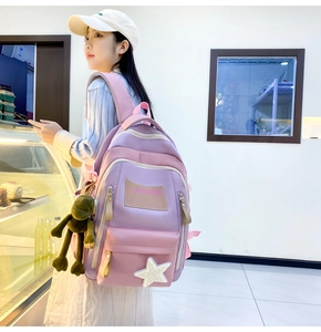 Side view of large student backpack in lavender and pink with green frog plush charm