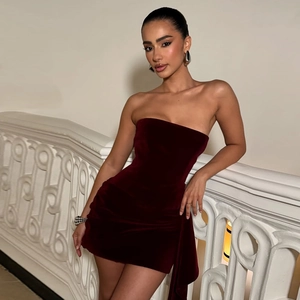 Close-up of velvet wine red tube dress with elegant side ribbons and ruched details