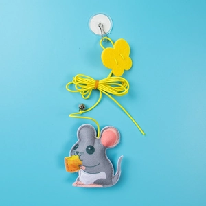 Macro view of hanging cat toy with mouse, yellow flower felt, bell and suction cup