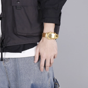 Detail of gold-plated stainless steel belt buckle bracelet on a male model's wrist