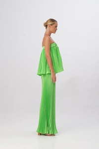 Dettaglio del completo a pieghe verde neon con top a fascia e pantaloni larghi