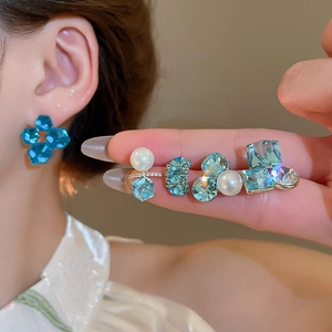 Detailed view of 18k gold plated silver earrings with blue zircon and elegant pearls