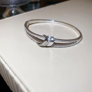 Vue détaillée du bracelet nœud argenté orné de zircons cubiques sur un support en cuir