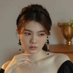 Close-up of elegant black beaded headband worn by model with matching accessories