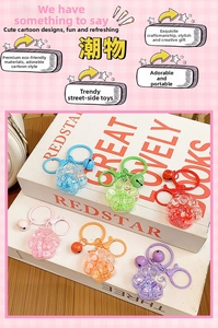 Close-up of six colorful cat paw oil liquid keychains with matching bells and sequins
