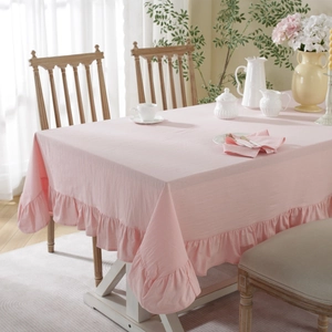 Close-up of pink cotton tablecloth featuring ruffled lotus edges and natural washed texture