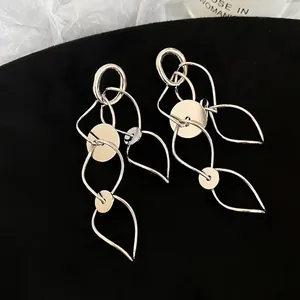 Silver geometric tassel drop earrings with metallic hollow circles on black velvet background