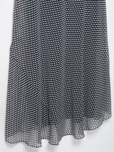 Close-up of lightweight chiffon hem with polka dot print and elegant draped fabric texture