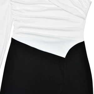 Detail of black and white patchwork dress featuring ruched fabric and irregular waist seam